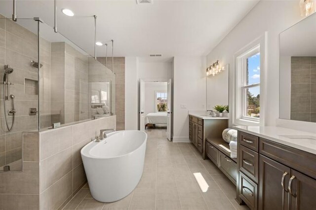 5247 Flannery Chase SW, Powder Springs, GA 30127 - ensuite bathroom featuring a tile shower, two vanities, tile patterned floors, a freestanding bath, and recessed lighting