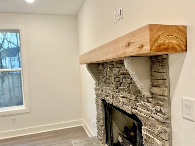 details featuring hardwood / wood-style floors and a stone fireplace