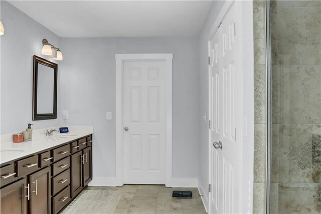 full bath featuring double vanity, baseboards, a sink, and a shower with shower door