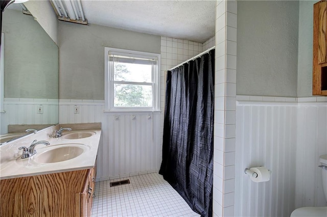 36 Skyview Cir, Cartersville, GA 30120 - full bathroom featuring a wainscoted wall, toilet, tile patterned floors, curtained shower, and a textured ceiling