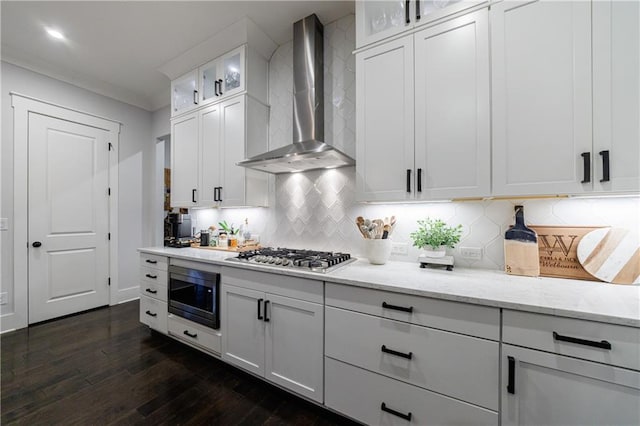 kitchen with white cabinetry, stainless steel gas stovetop, wall chimney exhaust hood, and built in microwave