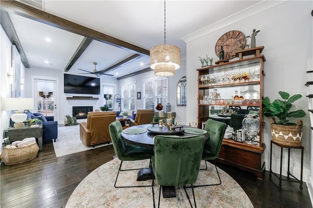 dining area featuring ceiling fan, beamed ceiling, and dark wood-type flooring