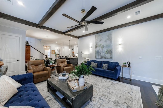 living room featuring beam ceiling, ceiling fan with notable chandelier, and hardwood / wood-style floors