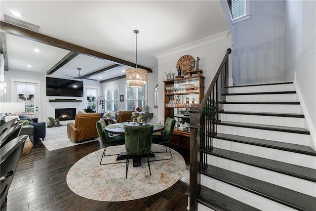 dining room featuring ceiling fan, beam ceiling, ornamental molding, and dark wood-type flooring