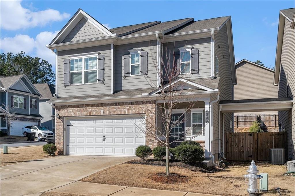 202 Bryon Ln, Acworth, GA 30102 - view of front of house featuring an attached garage, fence, central air condition unit, brick siding, and driveway