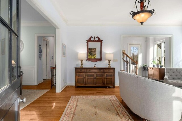 foyer with ornamental molding and light hardwood / wood-style flooring