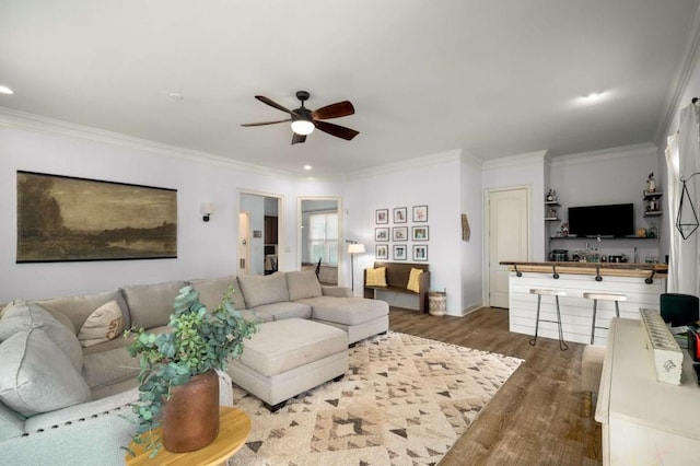 living room featuring ceiling fan, dark wood-type flooring, and crown molding