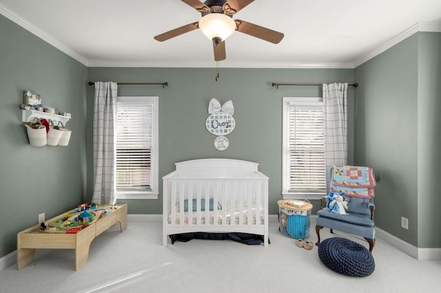 bedroom featuring a crib, carpet flooring, multiple windows, and ceiling fan