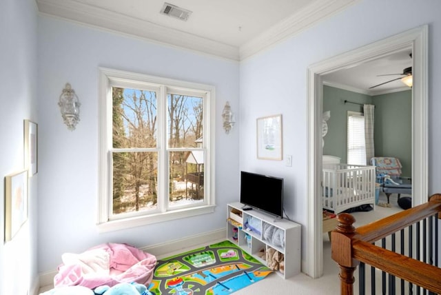 interior space with ceiling fan and crown molding