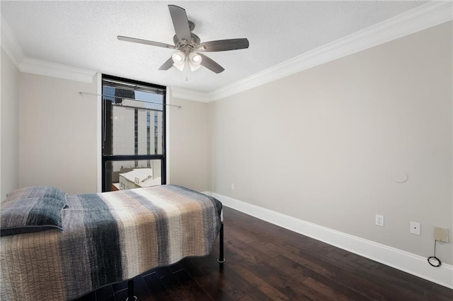 bedroom featuring a textured ceiling, ceiling fan, dark hardwood / wood-style floors, and ornamental molding