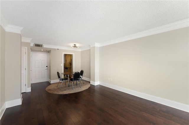 unfurnished dining area featuring dark hardwood / wood-style floors, ornamental molding, and a textured ceiling