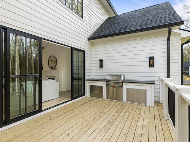 wooden deck with area for grilling and exterior kitchen