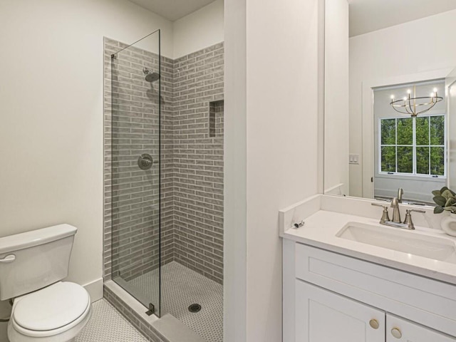 bathroom with toilet, a shower with shower door, an inviting chandelier, vanity, and tile patterned flooring