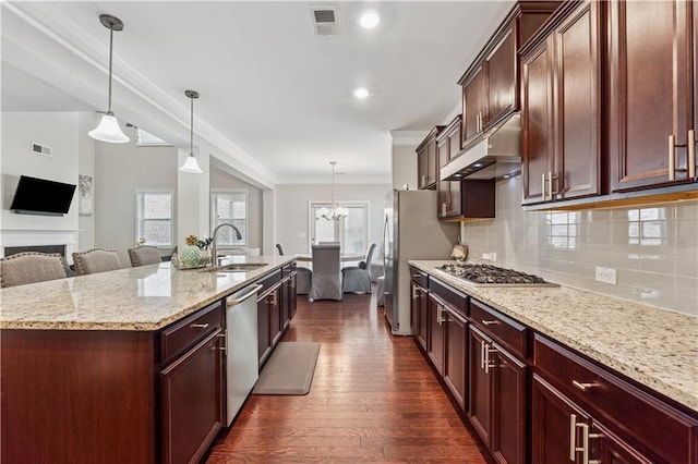 4050 Danbury Farms Dr, Cumming, GA 30040 - kitchen with stainless steel appliances, a sink, dark wood-style flooring, open floor plan, and under cabinet range hood