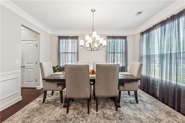 4050 Danbury Farms Dr, Cumming, GA 30040 - dining space featuring wood finished floors, visible vents, crown molding, and a notable chandelier