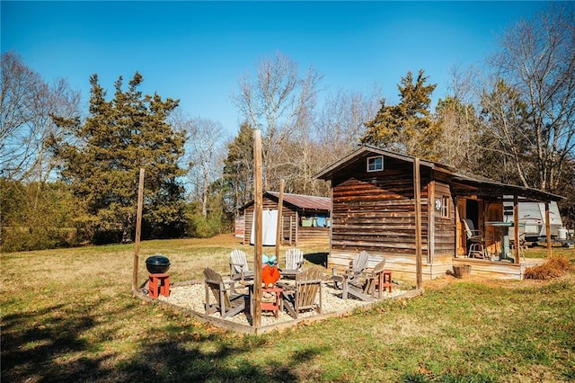 exterior space featuring a storage unit, an outdoor fire pit, and a yard