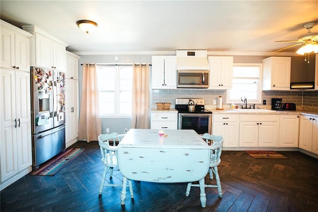 kitchen featuring stainless steel appliances, decorative backsplash, dark parquet floors, sink, and white cabinetry