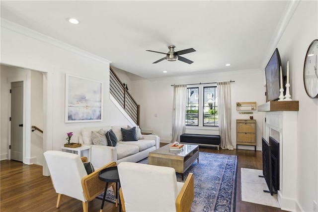 living area featuring dark wood finished floors, a fireplace with flush hearth, recessed lighting, stairs, and crown molding