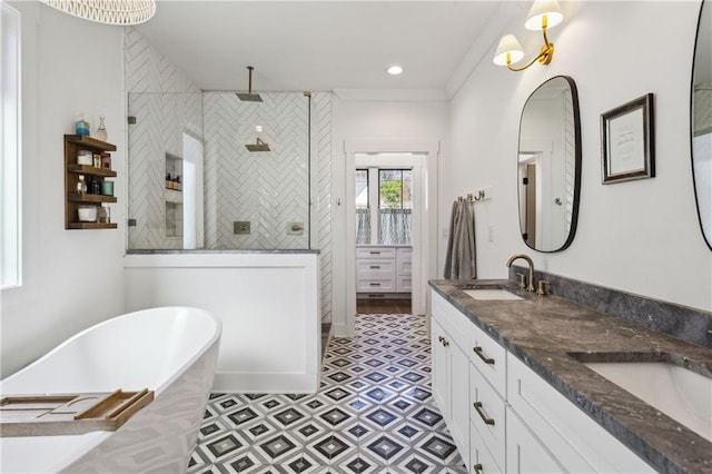 full bath featuring double vanity, a freestanding tub, tiled shower, and a sink