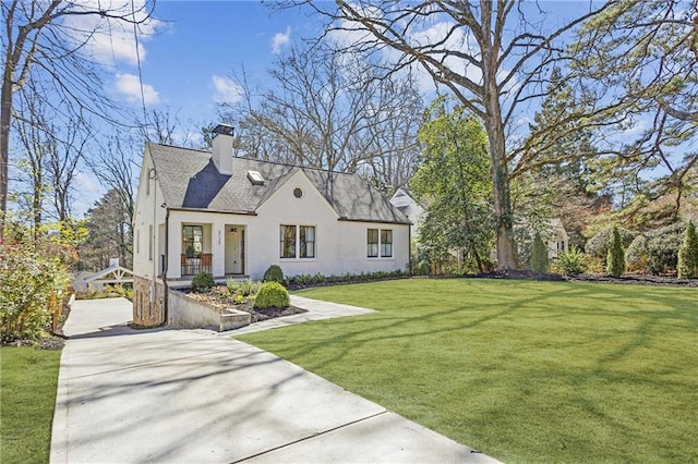 view of front facade with a front lawn, stucco siding, and a chimney