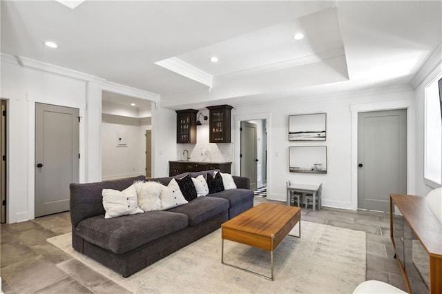 living area with indoor wet bar, recessed lighting, crown molding, and a tray ceiling