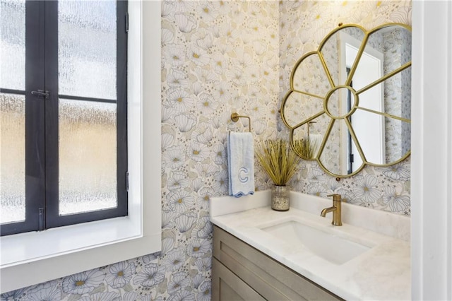 bathroom featuring french doors, wallpapered walls, and vanity