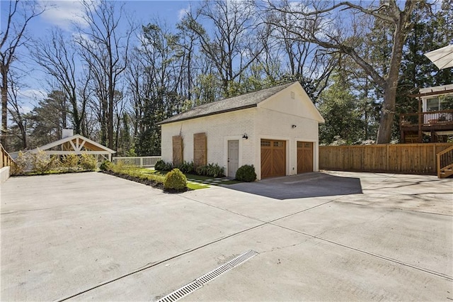 garage with fence and driveway