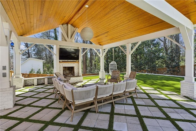 sunroom / solarium featuring vaulted ceiling, wood ceiling, and an outdoor brick fireplace