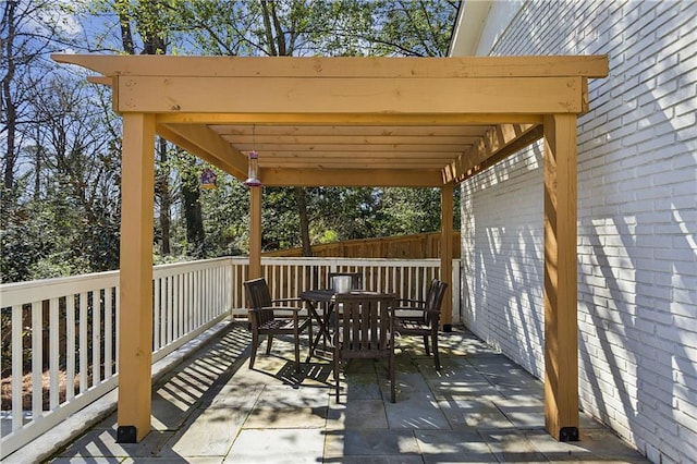 wooden terrace featuring a pergola, outdoor dining area, and fence