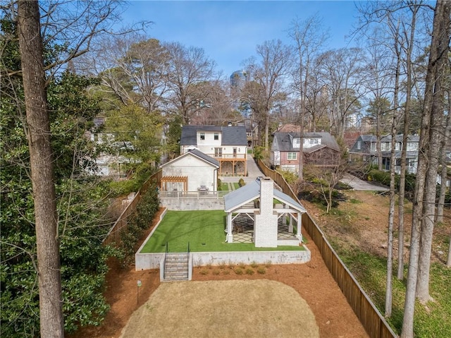 back of house with a gazebo, stairway, a lawn, and fence