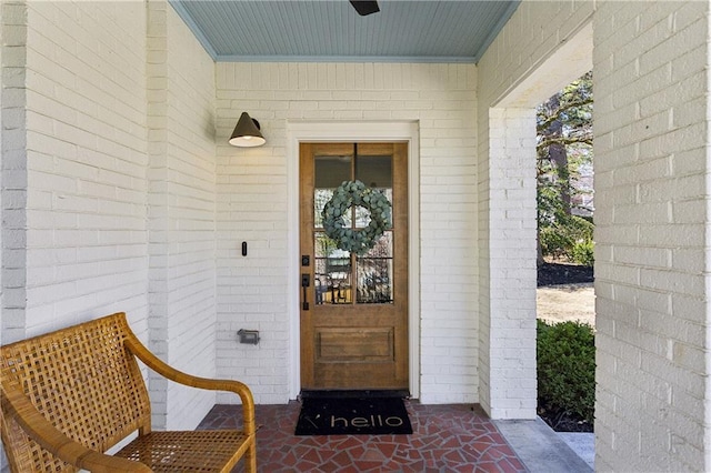 view of exterior entry featuring brick siding