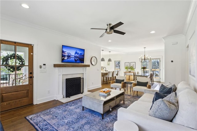 living area with recessed lighting, wood finished floors, and ornamental molding