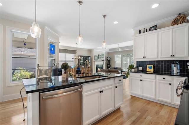 kitchen featuring white cabinets, appliances with stainless steel finishes, light hardwood / wood-style floors, sink, and pendant lighting