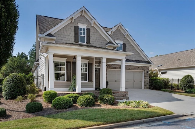 craftsman-style house featuring a garage, a porch, and a front yard