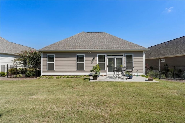 back of house with a lawn and a patio