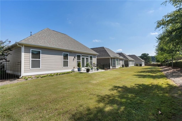 rear view of house with a lawn and a patio