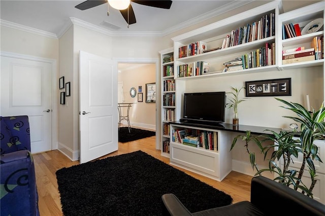 living room featuring crown molding, ceiling fan, and light hardwood / wood-style floors