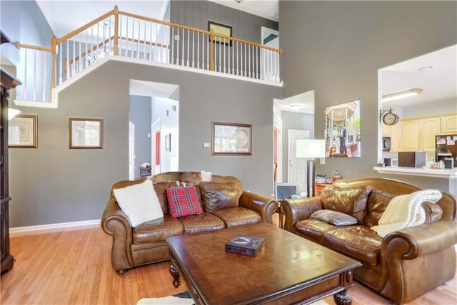 living room with light hardwood / wood-style flooring and a high ceiling