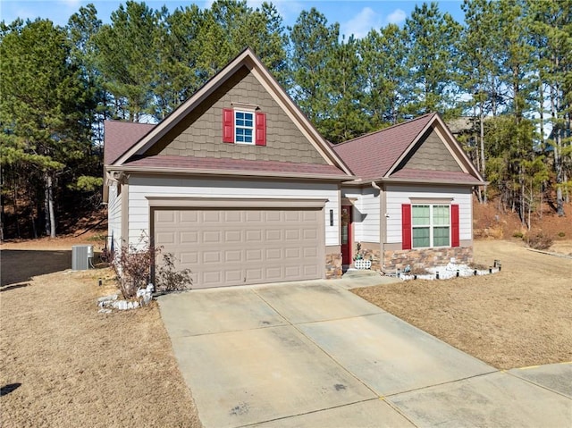 craftsman-style house featuring central AC unit and a garage