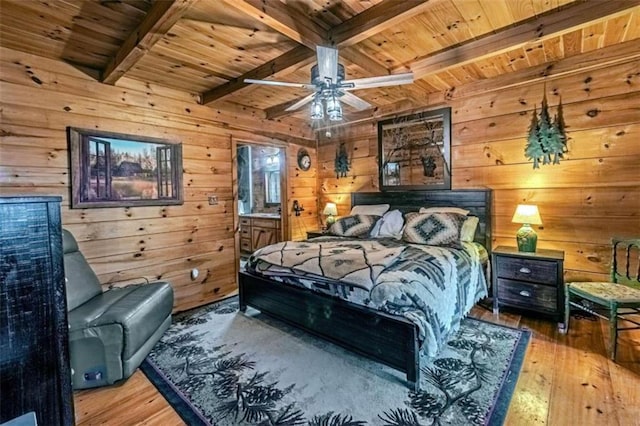 bedroom featuring beamed ceiling, wooden walls, wood-type flooring, wooden ceiling, and ensuite bathroom