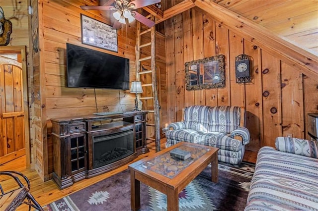 living room with ceiling fan, wooden walls, and hardwood / wood-style flooring