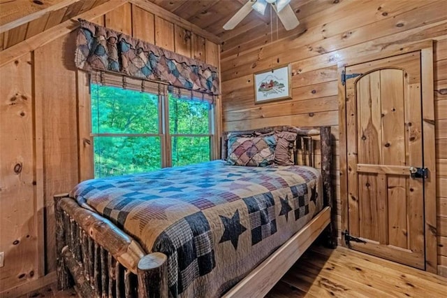 bedroom featuring wood ceiling, ceiling fan, wood walls, and light wood-type flooring