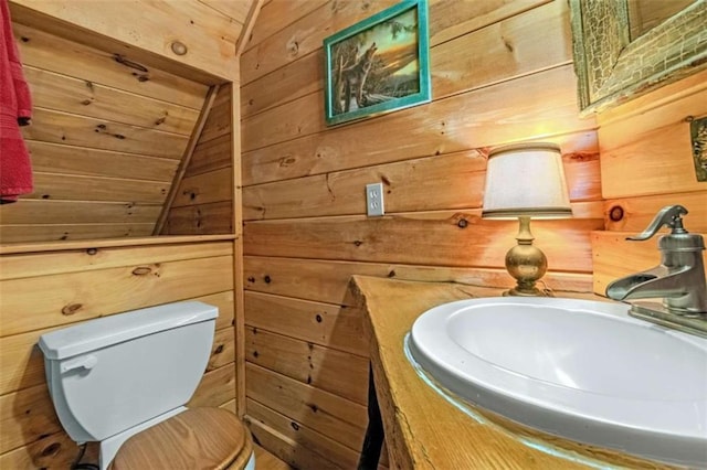 bathroom with vanity, toilet, wooden walls, and vaulted ceiling