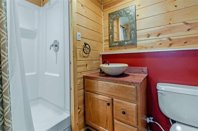 bathroom with curtained shower, wood walls, toilet, and vanity