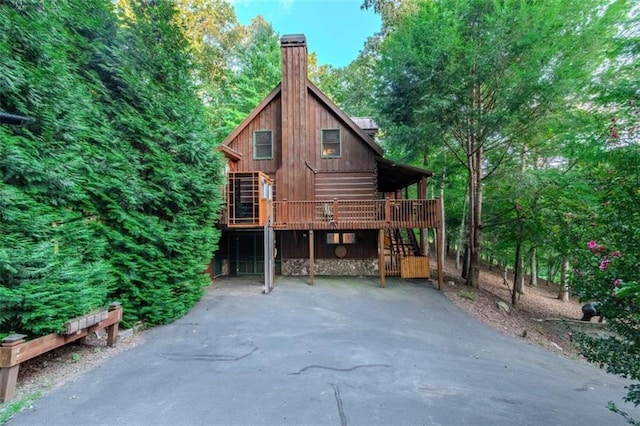 rear view of house with a carport and a wooden deck