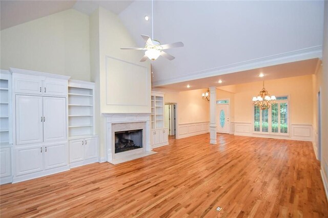 unfurnished living room with ceiling fan with notable chandelier, light hardwood / wood-style flooring, a high end fireplace, and lofted ceiling