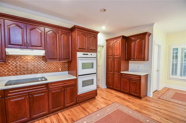 kitchen with white double oven, cooktop, tasteful backsplash, light hardwood / wood-style flooring, and crown molding