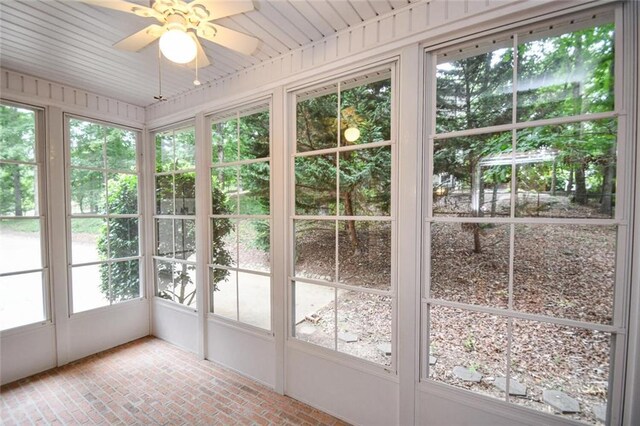 unfurnished sunroom featuring ceiling fan