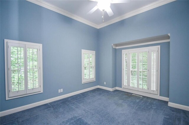 spare room with ceiling fan, dark carpet, and ornamental molding