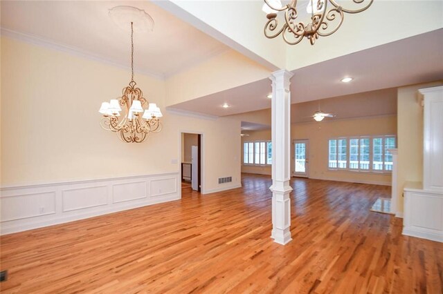 interior space with ornamental molding, light hardwood / wood-style flooring, ornate columns, and a notable chandelier